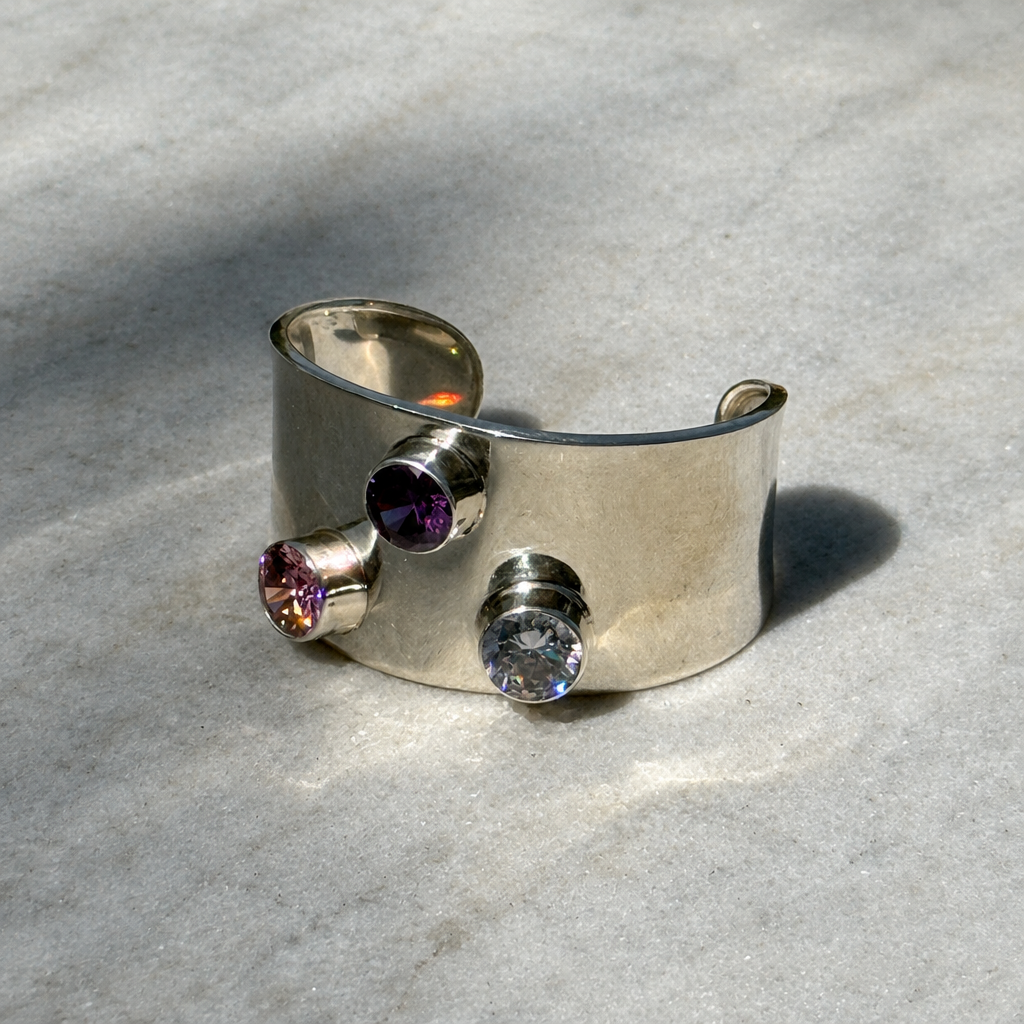 Sterling silver CZ cuff bracelet on a pale textured background